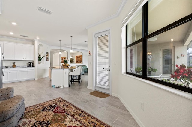 living room featuring arched walkways, ornamental molding, baseboards, light tile patterned flooring, and recessed lighting