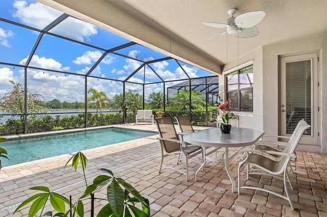 view of patio / terrace with an outdoor pool, a ceiling fan, a water view, outdoor dining space, and a lanai