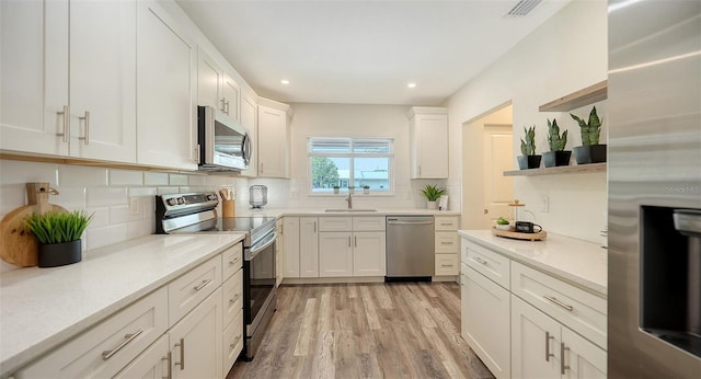 2825 Pinecrest St, Sarasota, FL 34239 - kitchen featuring appliances with stainless steel finishes, open shelves, light wood-type flooring, decorative backsplash, and white cabinets