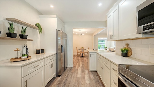 2825 Pinecrest St, Sarasota, FL 34239 - kitchen featuring stainless steel appliances, open shelves, light wood-type flooring, white cabinets, and light countertops