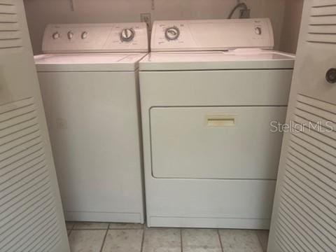 1212 Candlewood Dr, Lakeland, FL 33813 - laundry room with washing machine and clothes dryer and light tile patterned floors