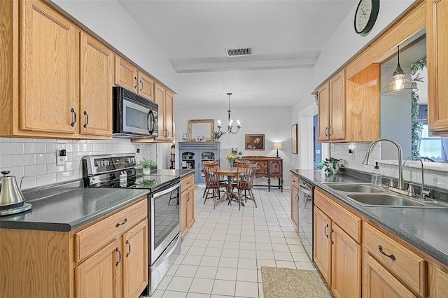 2708 27th Avenue Dr W, Bradenton, FL 34205 - kitchen with appliances with stainless steel finishes, dark countertops, light tile patterned floors, backsplash, and a chandelier
