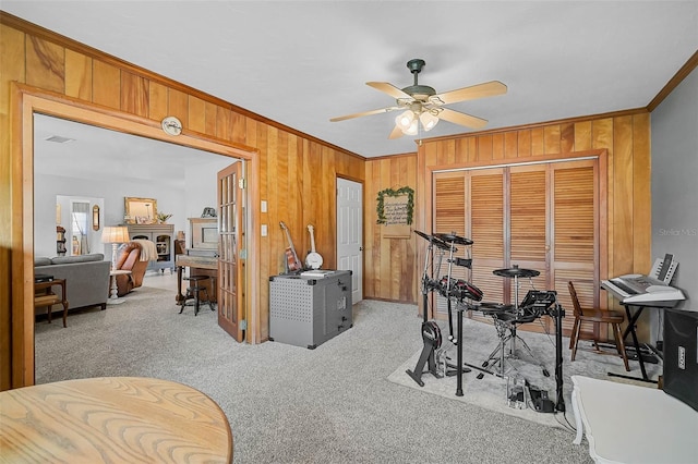 2708 27th Avenue Dr W, Bradenton, FL 34205 - workout room featuring crown molding, wooden walls, ceiling fan, light carpet, and a fireplace