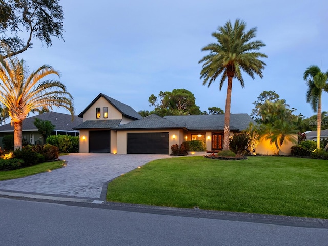 3905 Country View Dr, Sarasota, FL 34233 - view of front of home featuring a garage, a front lawn, stucco siding, and decorative driveway