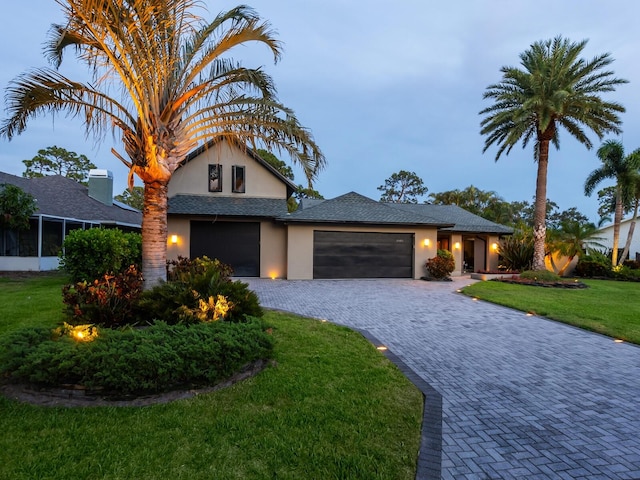 3905 Country View Dr, Sarasota, FL 34233 - traditional-style house featuring a garage, stucco siding, a front yard, and decorative driveway