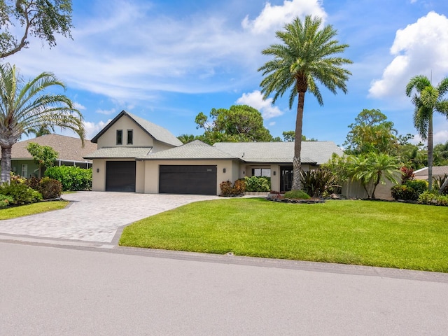 3905 Country View Dr, Sarasota, FL 34233 - view of front of property with a garage, a front yard, decorative driveway, and stucco siding