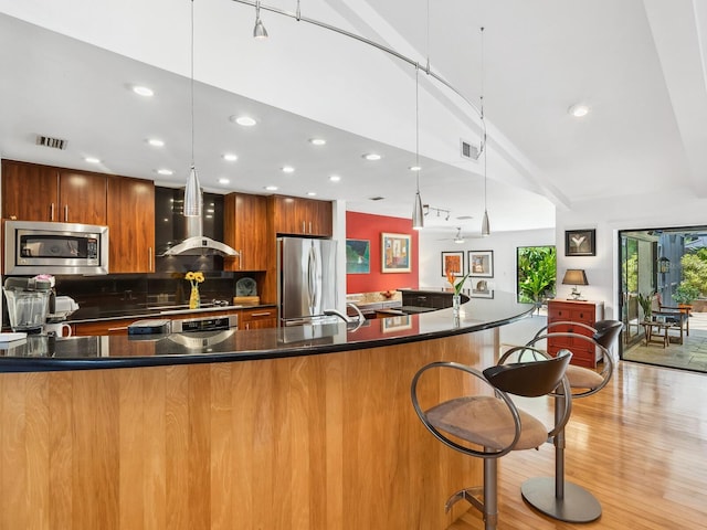 3905 Country View Dr, Sarasota, FL 34233 - kitchen featuring stainless steel appliances, wall chimney range hood, modern cabinets, recessed lighting, and a breakfast bar area