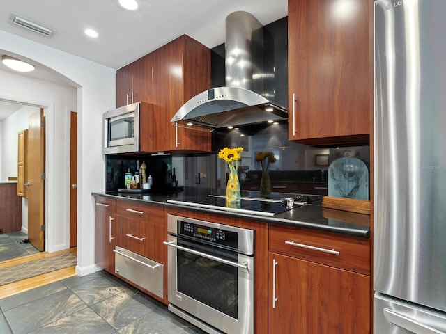 3905 Country View Dr, Sarasota, FL 34233 - kitchen with stainless steel appliances, wall chimney range hood, a warming drawer, dark countertops, and tasteful backsplash