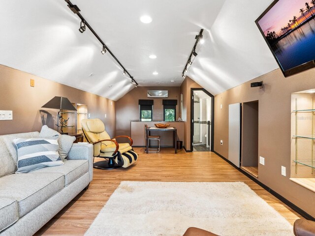 3905 Country View Dr, Sarasota, FL 34233 - living area with track lighting, lofted ceiling, wood finished floors, and baseboards