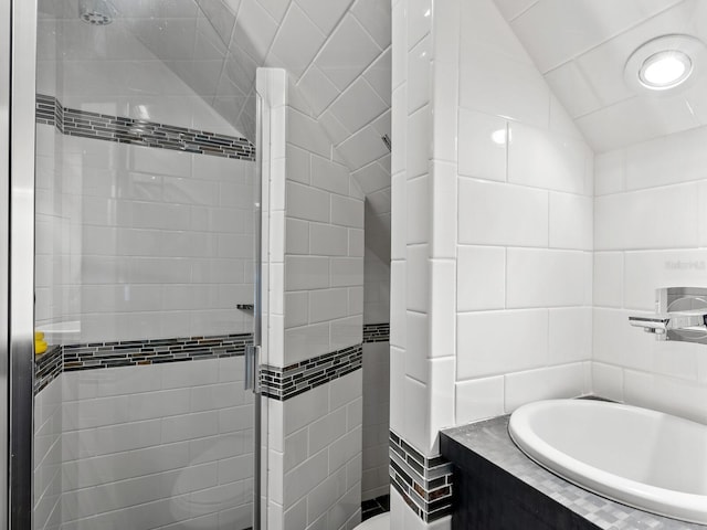 3905 Country View Dr, Sarasota, FL 34233 - bathroom featuring a shower stall, tile walls, lofted ceiling, and a garden tub