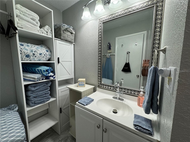 bathroom with vanity and a textured wall