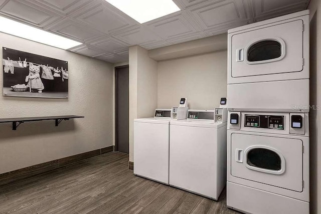 shared laundry featuring estacked washer and dryer, wood finished floors, separate washer and dryer, an ornate ceiling, and baseboards