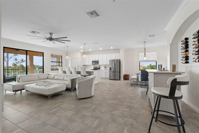 10820 Tarflower Dr Unit 202, Venice, FL 34293 - living area with a ceiling fan, healthy amount of natural light, crown molding, recessed lighting, and baseboards