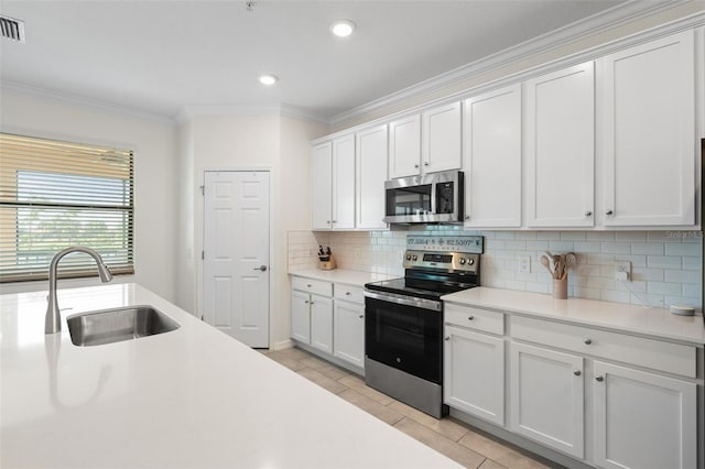 10820 Tarflower Dr Unit 202, Venice, FL 34293 - kitchen with appliances with stainless steel finishes, a sink, ornamental molding, tasteful backsplash, and light countertops