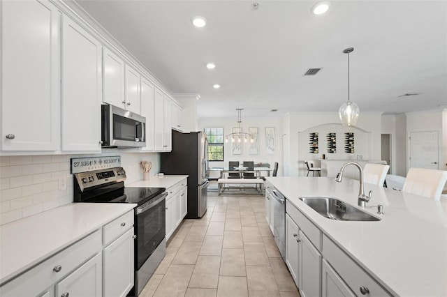 10820 Tarflower Dr Unit 202, Venice, FL 34293 - kitchen with stainless steel appliances, a sink, pendant lighting, backsplash, and white cabinets