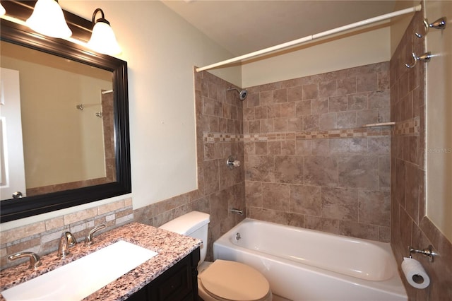 bathroom featuring bathing tub / shower combination, toilet, tile walls, and vanity