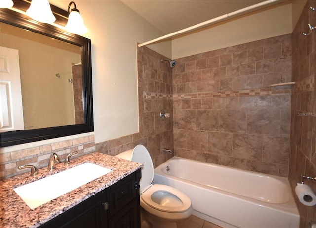 full bath featuring shower / bath combination, toilet, vanity, and tile walls