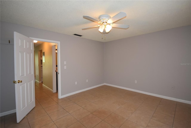 unfurnished room with ceiling fan, light tile patterned floors, and baseboards