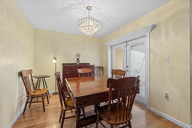 6207 Courtside Dr Unit 23, Bradenton, FL 34210 - dining room with french doors, light wood-style floors, a chandelier, and baseboards