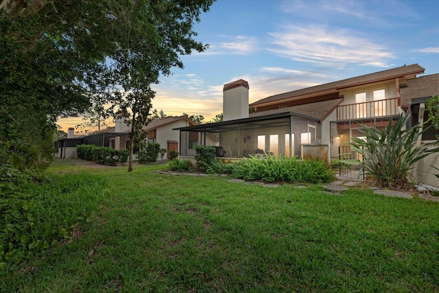 6207 Courtside Dr Unit 23, Bradenton, FL 34210 - back of property at dusk with a lawn, a chimney, and stucco siding