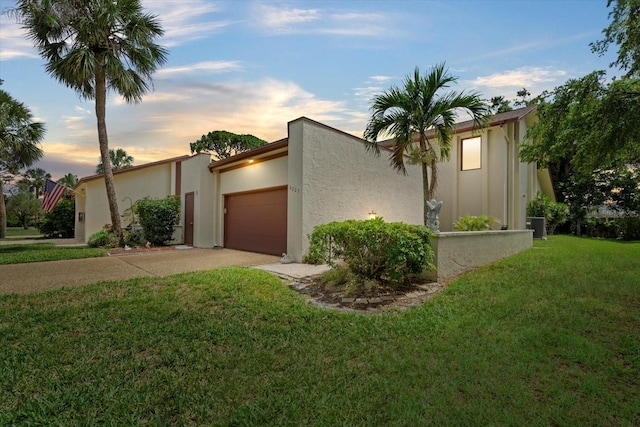 6207 Courtside Dr Unit 23, Bradenton, FL 34210 - view of front of home with an attached garage, a front yard, driveway, stucco siding, and central air condition unit