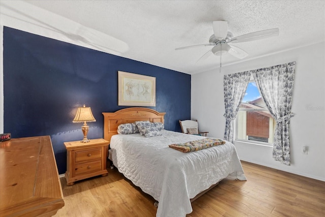6207 Courtside Dr Unit 23, Bradenton, FL 34210 - bedroom featuring a textured ceiling, wood finished floors, ceiling fan, and baseboards