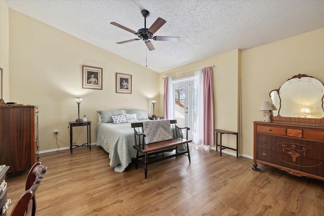 6207 Courtside Dr Unit 23, Bradenton, FL 34210 - bedroom with a textured ceiling, lofted ceiling, access to exterior, light wood-style flooring, and baseboards