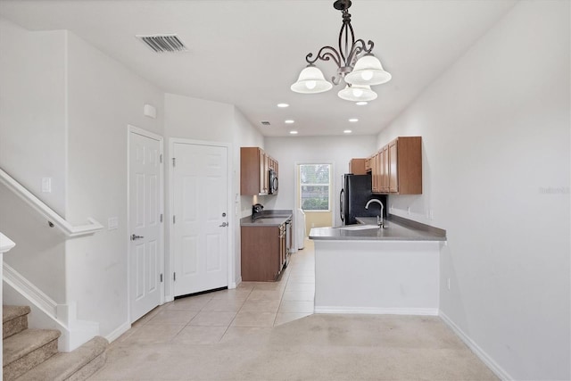 3760 82nd Avenue Cir E Unit 102, Sarasota, FL 34243 - kitchen with electric range, freestanding refrigerator, a sink, a chandelier, and brown cabinetry