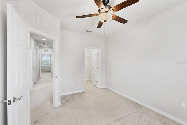 3760 82nd Avenue Cir E Unit 102, Sarasota, FL 34243 - unfurnished bedroom featuring light carpet, baseboards, ceiling fan, and a walk in closet