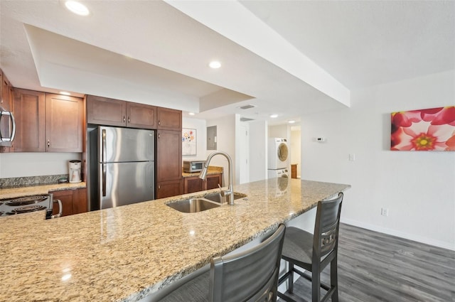 101 S Gulfstream Ave Unit 6C, Sarasota, FL 34236 - kitchen with appliances with stainless steel finishes, a sink, washer / clothes dryer, a raised ceiling, and baseboards