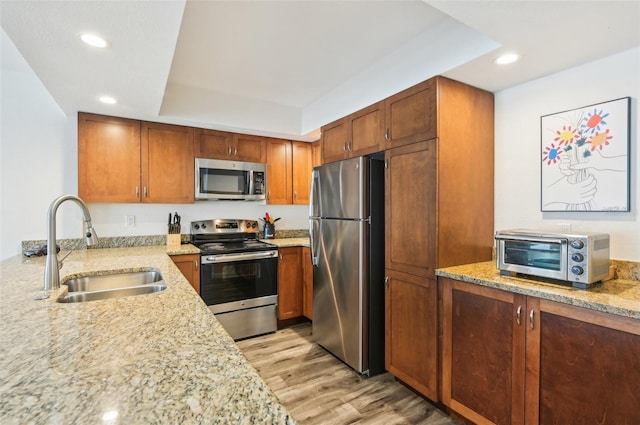 101 S Gulfstream Ave Unit 6C, Sarasota, FL 34236 - kitchen featuring appliances with stainless steel finishes, a sink, light stone countertops, light wood finished floors, and recessed lighting