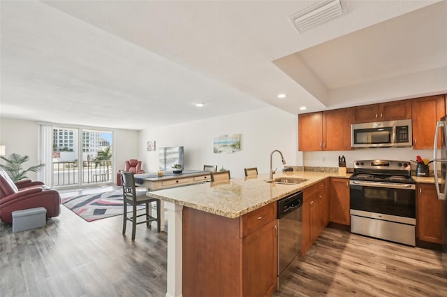101 S Gulfstream Ave Unit 6C, Sarasota, FL 34236 - kitchen featuring stainless steel appliances, a sink, open floor plan, a peninsula, and wood finished floors