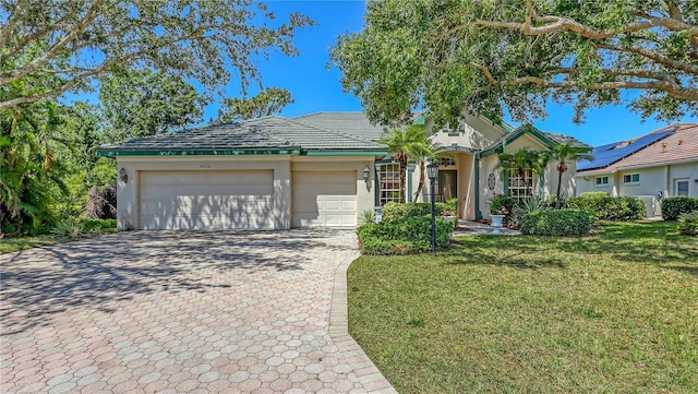 4920 Woodhurst Dr, Sarasota, FL 34243 - ranch-style home featuring an attached garage, decorative driveway, a front yard, and stucco siding