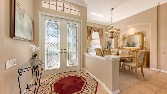 4920 Woodhurst Dr, Sarasota, FL 34243 - foyer with french doors, a chandelier, light tile patterned floors, crown molding, and baseboards