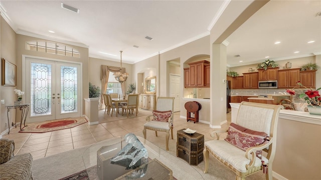 4920 Woodhurst Dr, Sarasota, FL 34243 - living room featuring french doors, light tile patterned flooring, arched walkways, baseboards, and crown molding