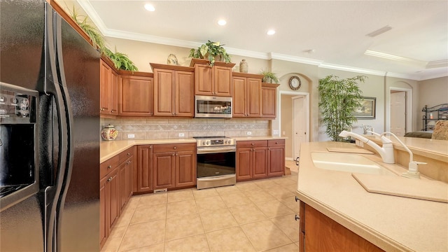 4920 Woodhurst Dr, Sarasota, FL 34243 - kitchen with appliances with stainless steel finishes, a sink, decorative backsplash, light countertops, and brown cabinets