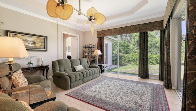 4920 Woodhurst Dr, Sarasota, FL 34243 - tiled living room featuring crown molding, arched walkways, a tray ceiling, baseboards, and a ceiling fan