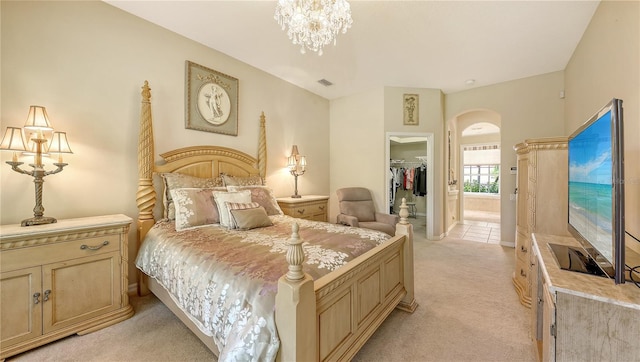 4920 Woodhurst Dr, Sarasota, FL 34243 - bedroom with arched walkways, a spacious closet, light colored carpet, a closet, and ensuite bath