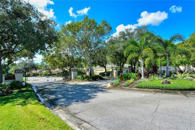 4920 Woodhurst Dr, Sarasota, FL 34243 - view of asphalt street featuring curbs, a gate, and a gated entry