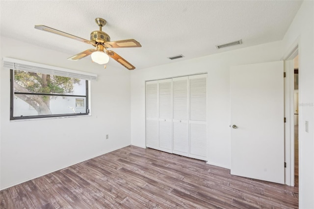 104 Hourglass Dr, Venice, FL 34293 - unfurnished bedroom with a closet, wood finished floors, a ceiling fan, and a textured ceiling