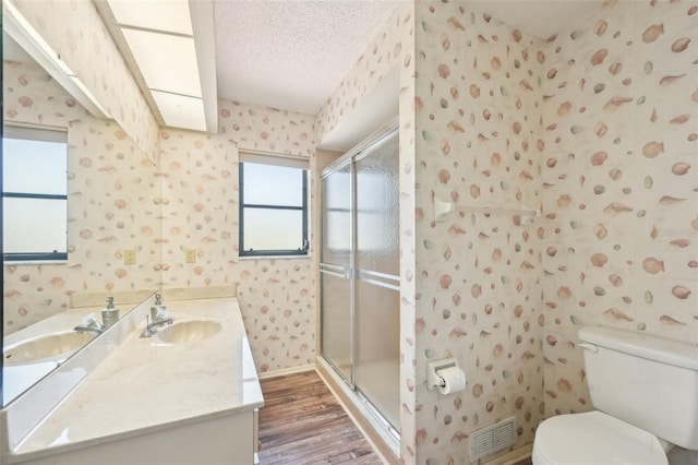 104 Hourglass Dr, Venice, FL 34293 - full bath with wallpapered walls, wood finished floors, toilet, a textured ceiling, and a shower stall