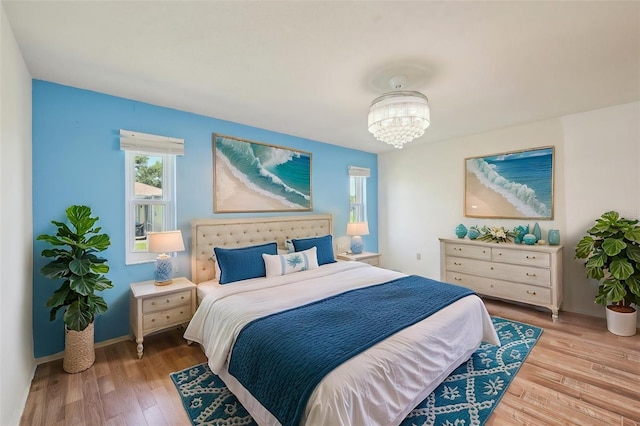 104 Hourglass Dr, Venice, FL 34293 - bedroom featuring multiple windows, wood finished floors, a chandelier, and baseboards