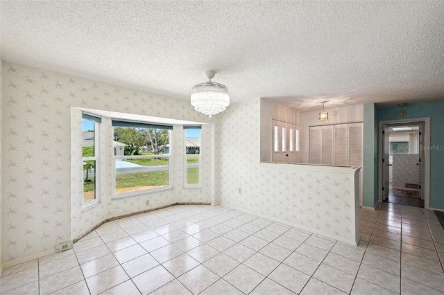 104 Hourglass Dr, Venice, FL 34293 - unfurnished dining area featuring wallpapered walls, light tile patterned floors, a chandelier, a textured ceiling, and baseboards