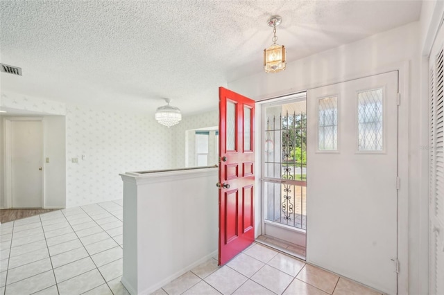 104 Hourglass Dr, Venice, FL 34293 - foyer featuring wallpapered walls, light tile patterned flooring, and a textured ceiling
