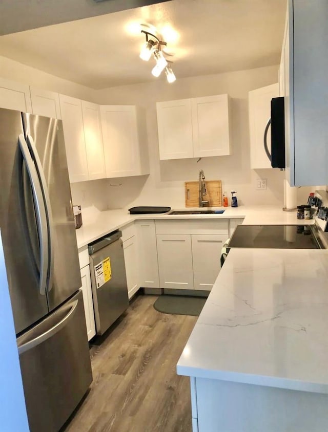 5855 Midnight Pass Rd Unit 621, Sarasota, FL 34242 - kitchen with appliances with stainless steel finishes, a sink, wood finished floors, and white cabinets