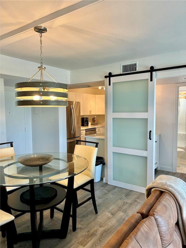 5855 Midnight Pass Rd Unit 621, Sarasota, FL 34242 - dining room featuring a barn door, light wood finished floors, and baseboards