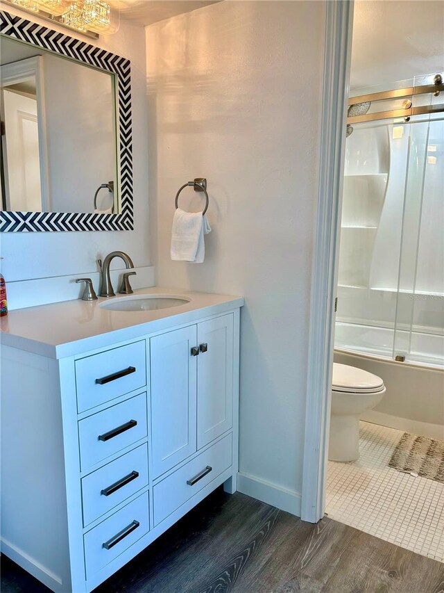5855 Midnight Pass Rd Unit 621, Sarasota, FL 34242 - bathroom with wood finished floors, toilet, vanity, combined bath / shower with glass door, and baseboards