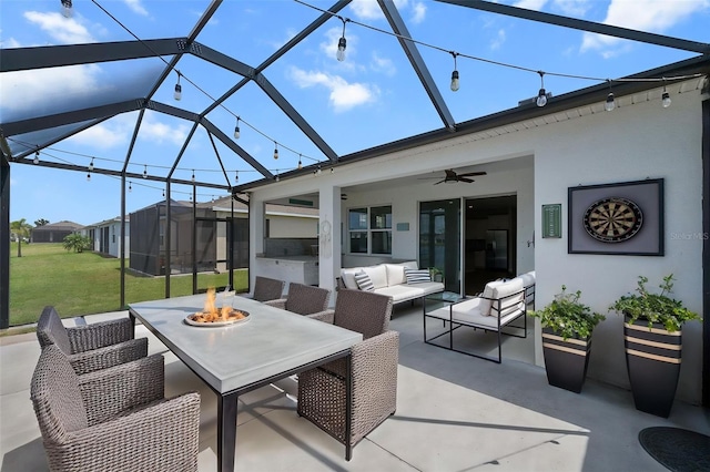 view of patio with an outdoor living space with a fire pit, ceiling fan, and glass enclosure