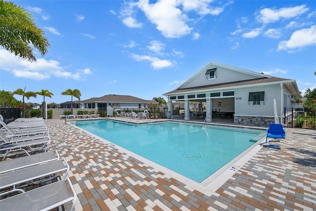 community pool featuring fence and a patio area
