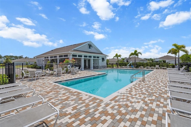 community pool featuring fence and a patio area
